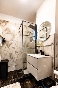 a bathroom with a white sink and a shower at Luxury Riverside Apartment Băile Herculane in Băile Herculane