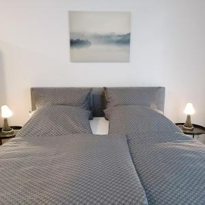 a bedroom with two beds and two lamps on tables at TauberNest in Bad Mergentheim