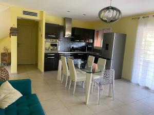 a kitchen with a table and chairs in a room at Villa avec piscine privée à 10 min Porto-Vecchio in Lecci