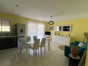 a kitchen and living room with a table and chairs at Villa avec piscine privée à 10 min Porto-Vecchio in Lecci
