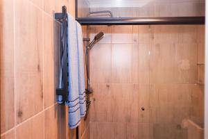 a shower in a bathroom with a blue towel at Pousada Kaporã in Bocaiúva do Sul