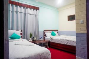 - une chambre avec 2 lits et un tapis rouge dans l'établissement Manthali Park Inn, à Rāmechhāp
