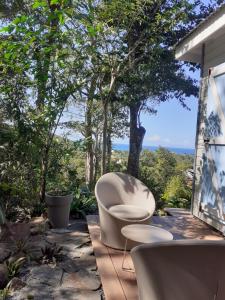 a white chair sitting on a patio with trees at surf lodge in Deshaies