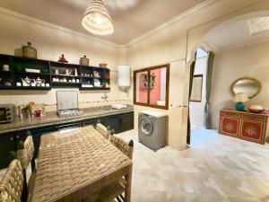 a kitchen with a table and a washing machine at Spacieux & confortable, parfait pour familles ou séjours tranquilles in Marrakech +31 photos