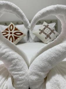 Una cama con dos toallas en forma de corazón. en Pousada Beira dagua, en Acaraú