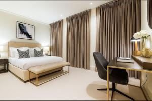 ein Hotelzimmer mit Bett und Schreibtisch in der Unterkunft Premier 3 Bed Luxury Apartment in Covent Garden in London + 7 Fotos