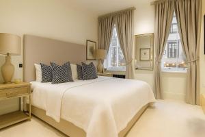 1 Schlafzimmer mit einem weißen Bett und 2 Fenstern in der Unterkunft Premier 3 Bed Luxury Apartment in Covent Garden in London