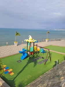 a playground with a play equipment on the grass at Cómoda Casa con vista al Mar en Manta in Manta