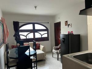 a kitchen with a refrigerator and a living room at Alojamiento Los Ángeles in Santa Marta +5 photos