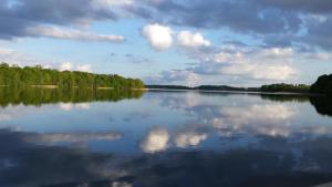 a large lake with trees and clouds in the water at Villa Amilia - Ferienwohnung 2 in Waren