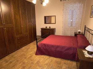 a bedroom with a red bed and wooden cabinets at Casa Vacanze da Nonna Chiarina in Anagni