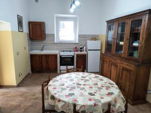 a kitchen with a table and a white refrigerator at Casa Vacanze da Nonna Chiarina in Anagni