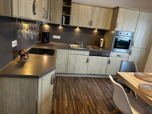 a kitchen with wooden cabinets and a counter top at Hof Quartier 6 in Neunkirchen