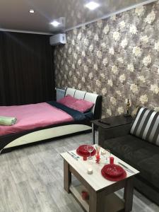 a room with two beds and a couch and a table at Аренда квартир in Rudny