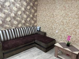 a living room with a couch and a table at Аренда квартир in Rudny