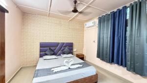 a bedroom with a blue bed with towels on it at Royal Palace in Dibrugarh