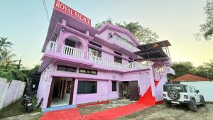 a pink house with a truck parked in front of it at Royal Palace in Dibrugarh