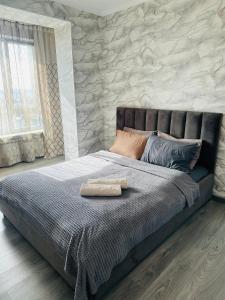a bedroom with a bed with a stone wall at Аэропорт apartments in Pokrovka