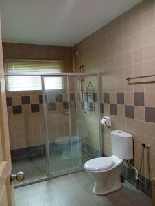 a bathroom with a toilet and a glass shower at Marina Island Seafront Villa by Monte Villas in Lumut