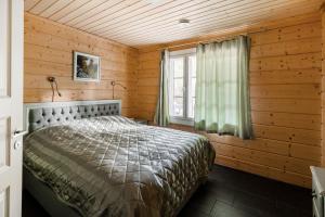 a bedroom with a bed in a wooden room at Beautiful house and sauna on the lake, 175 m2 in Lappeenranta