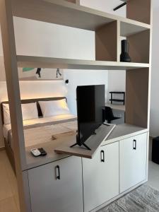 a room with a bunk bed and a desk with a television at Nesseus Lux Suites - Near Unic & EUC in Ayios Dhometios