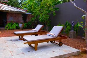 - deux chaises longues assises sur une terrasse dans l'établissement Dhyana Beach Villa, à Ambalangoda