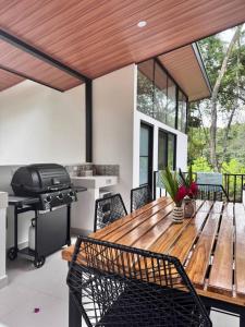 d'une terrasse avec une table en bois et un grill. dans l'établissement Mermaid House, à Matapalo