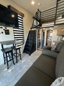 a living room with a couch and a table and a staircase at Prairie Dog Perch Tiny Home in Interior