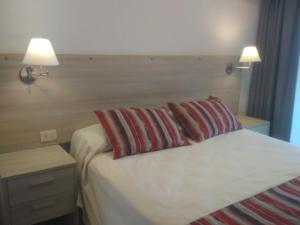 une chambre avec un lit avec deux oreillers dessus dans l'établissement Solares de Araus 103, à Colonia del Sacramento 8 autres photos