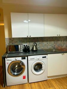 a kitchen with a washing machine and a microwave at Near City-Birkenhead rooms in Birkenhead