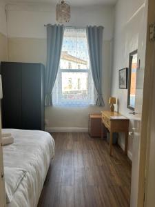 a bedroom with a bed and a window and a desk at Near City-Birkenhead rooms in Birkenhead