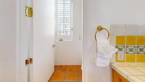 a bathroom with a sink and a towel on a door at SV253 2BR 3BA Spa Villa with Pool Access & Views in La Quinta