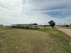 a building with a fence in the middle of a field at Grasshopper Flats RV Pad in Interior