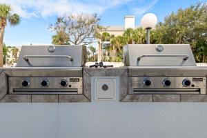 Dos lavabos en una pared con árboles al fondo. en Gulf Tides of Longboat Key, en Longboat Key