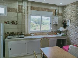 a kitchen with a sink and a window and a table at vacdellys in Boumerdes +16 photos
