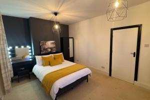 a bedroom with a large bed with yellow pillows at Downtown Loughborough Escape 3BR Flat for 6 Guests in Loughborough