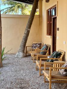 a row of wooden benches with pillows on them at Kasuku Villa in Dimbuni