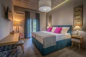 a bedroom with a large bed with pink pillows at Rivazzurra Beachfront Luxury Villa in Lithakia +55 photos