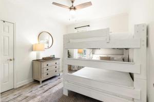 ein weißes Etagenbett in einem Schlafzimmer mit einer Kommode in der Unterkunft Blue Mountain Pool 4 Bedrooms Sleeps 12 in Blue Gulf Beach + 39 Fotos