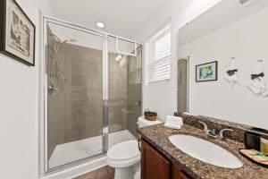 a bathroom with a shower and a toilet and a sink at Southern Oak Cottage in Ladson +18 photos