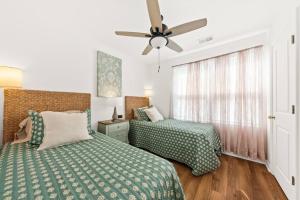 a bedroom with two beds and a ceiling fan at Southern Oak Cottage in Ladson