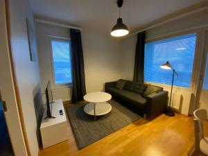 a living room with a couch and a table at Modern Apartment for 3 with Sauna in Kemi