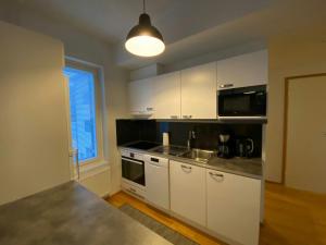 a kitchen with white cabinets and a counter top at Modern Apartment for 3 with Sauna in Kemi