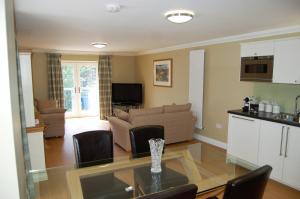 a kitchen and a living room with a glass table at Allt Nan Ros Apartments fort william in Onich