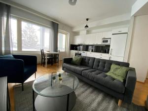 a living room with a couch and a table at Modern Apartment for 2 with Sauna in Kemi