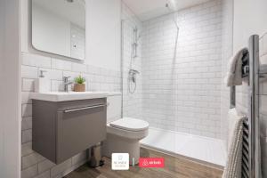 a bathroom with a toilet and a sink and a tub at Beachside Retreat l Sun Terrace l Hot Tub l Free Parking l Seaside Escapes Short Lets & Serviced Accommodation in Bournemouth