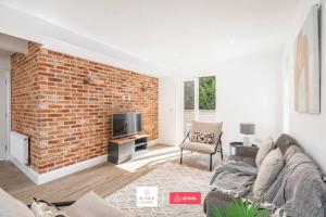 a living room with a brick wall and a couch at Beachside Retreat l Sun Terrace l Hot Tub l Free Parking l Seaside Escapes Short Lets & Serviced Accommodation in Bournemouth