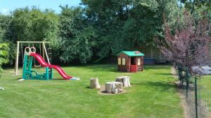 un parque infantil con tobogán y una casa pequeña en Le Clos des Meix, en Lanthes