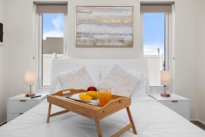a tray of fruit on a bed in a bedroom at Seroe Blanco Stylish in Tanki Lender +26 photos