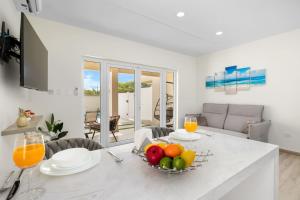 a kitchen with a table with a bowl of fruit on it at Dreamy Getaway w/ Private Pool | BBQ |5min Airport in Tanki Lender
